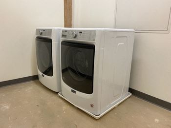 Two front loading washing machines in a laundry room.